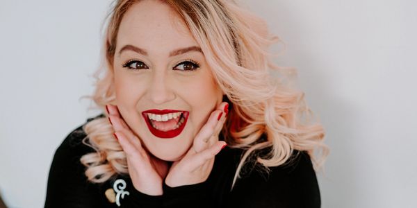 Happy woman with bright red lipstick smiling.