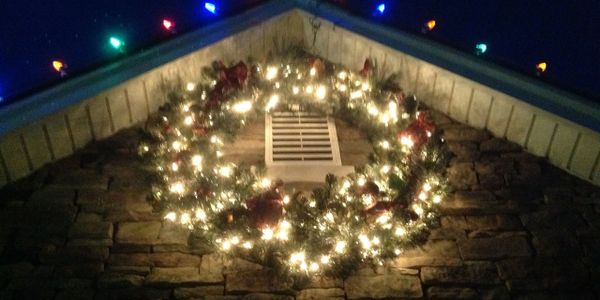 Festive wreath placed on a peaks eve with peak lights at night