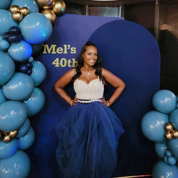 Woman posing in elegant dress at 40th birthday celebration.