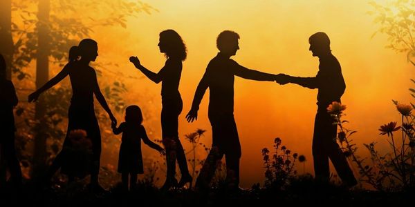 Silhouettes of people interacting during a golden sunset in a natural setting.