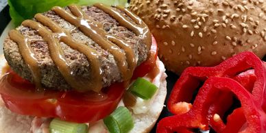 A plate with an open burger with bread, red bell pepper and lettuce