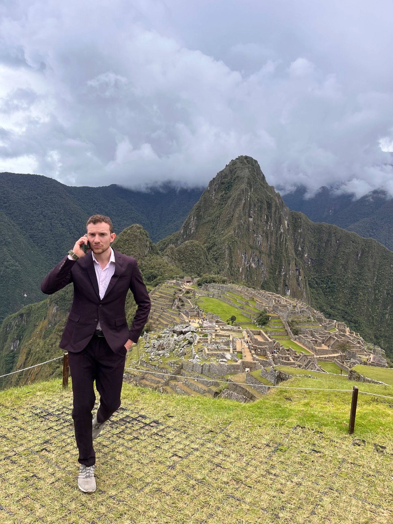 Standing in a suit at the top of Machu Pichu Peru