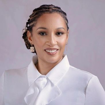 Professional woman with braided hair and white blouse smiling.