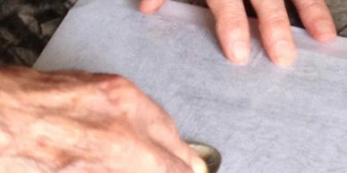 Hands sorting coins on a surface.