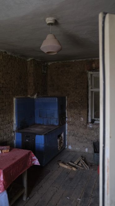 Rustic kitchen with an old blue stove and bare brick walls.