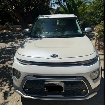 Front view of a white Kia car parked outdoors.