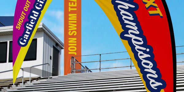 Colorful banners promoting the Garfield Gators swim team at empty bleachers.