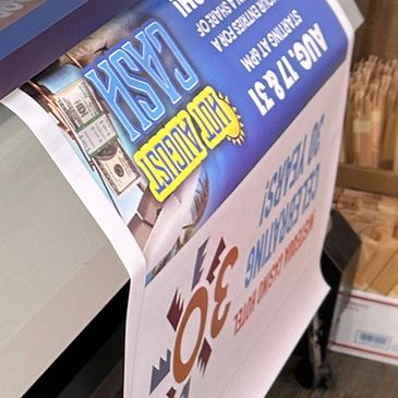 A poster being printed advertising a cash giveaway event on August 17-31.