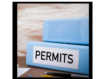 Blue binder labeled 'PERMITS' on a desk.