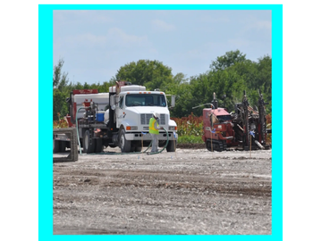 Worker and truck at construction site with equipment.