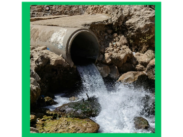 Water flowing out of a concrete pipe into a rocky area.