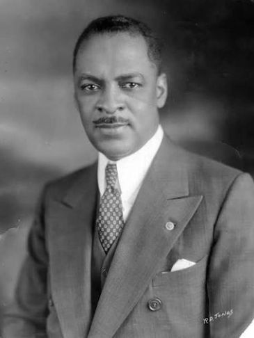 Black and white portrait of a man in a suit and tie.