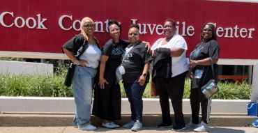 Five women standing in front of Cook County Juvenile Center sign.