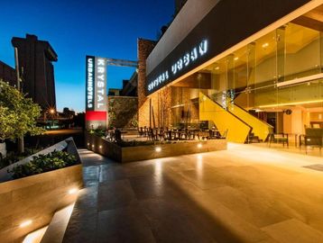 Entrada iluminada de un hotel moderno al atardecer.