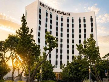 Edificio de hotel Ejecutivo Express al atardecer.