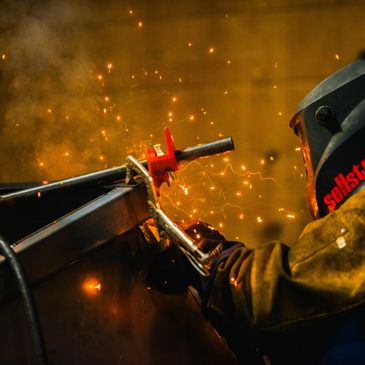 Elite Containers welder cutting steel in the Waterbury shop