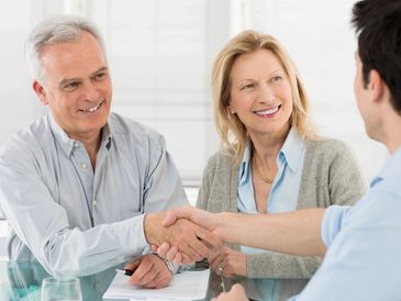 Senior Happy Couple Shaking Hand With Financial Advisor