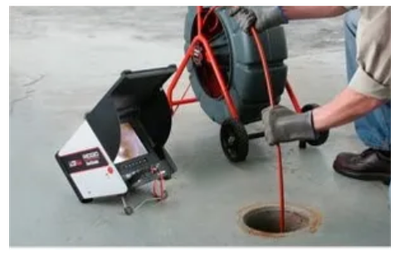 Person using a drain inspection camera on a floor drain.