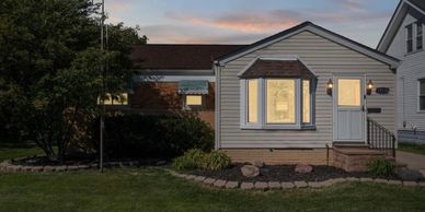 A cozy house at dusk with lit windows.
