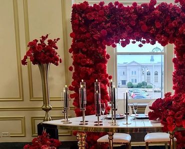 Elegant dining setup with red roses and tall candles.