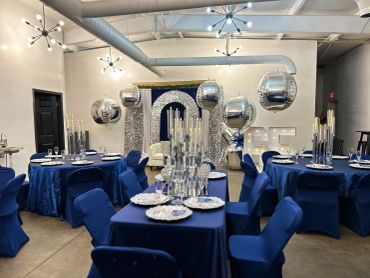 Elegant blue and silver event setup with candles and mirrored balloons.