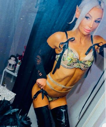 Woman posing in lingerie and thigh-high boots.