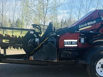 A Ditch Witch trencher machine on a trailer with a 'Rent Me!' sign.
