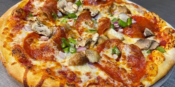 A freshly baked pizza with pepperoni, mushrooms, green peppers, and sausage. From a Greeley restaurant