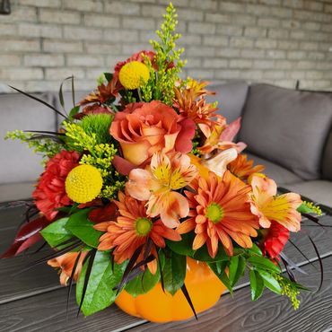 Orange ceramic pumpkin flower arrangement with orange roses