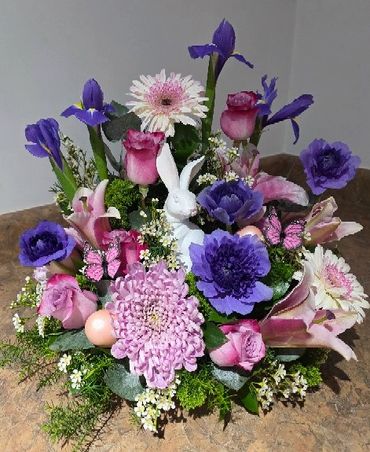 Colorful flower arrangement with a white bunny figure.