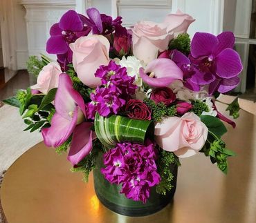 Orchids, pink roses and calla lily flower arrangement in clear vase