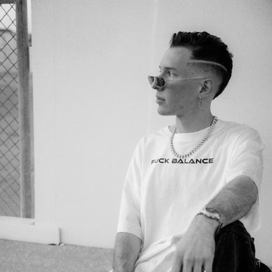 Young man with stylish haircut and sunglasses gazing sideways.