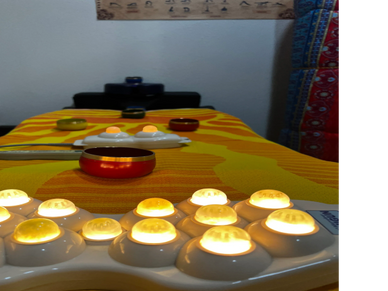 A cozy setup with lit candles and bowls on a striped orange tablecloth.