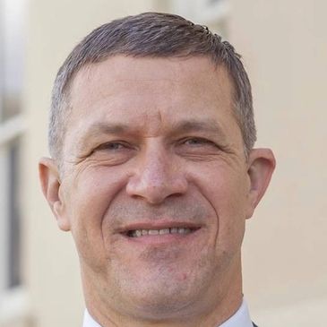 Smiling middle-aged man in outdoor setting.