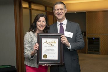 Two people holding an Assembly certificate.