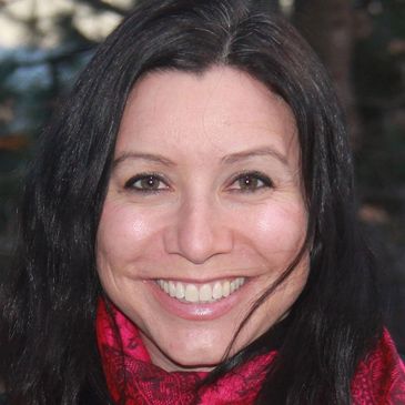 Smiling woman with dark hair and red scarf.