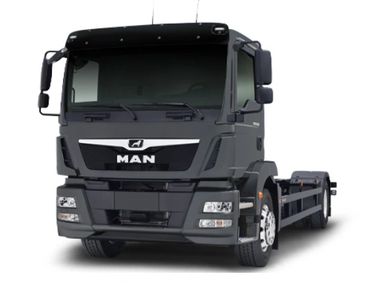 Black MAN truck with a flatbed chassis, front view.