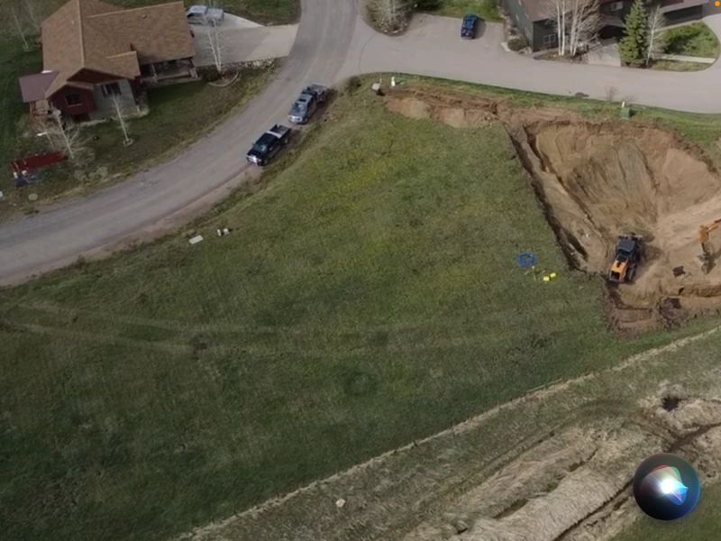 A residential area with a construction site and parked trucks.