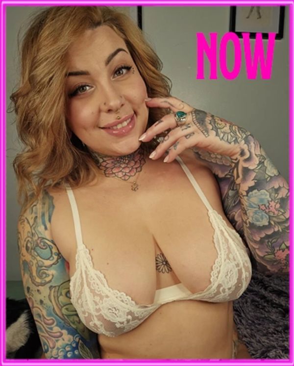 Smiling woman with colorful tattoos and lace lingerie.