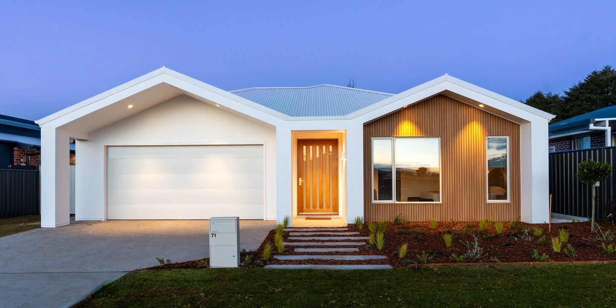 Modern house with wooden and white exterior at dusk.