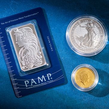 A platinum pamp bar, a silver brittania, and a new gold sovereign on a blue background.