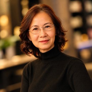 Woman with glasses and a warm smile.
