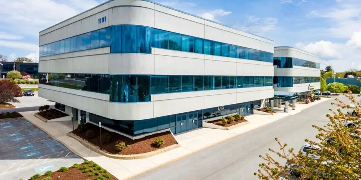 Modern office buildings with blue-tinted glass windows on a sunny day.
