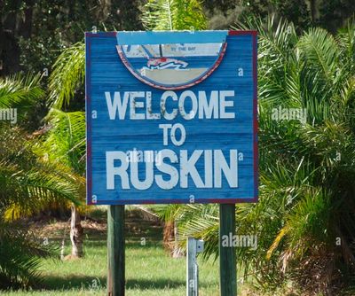 Welcome sign for Ruskin surrounded by palm trees.
