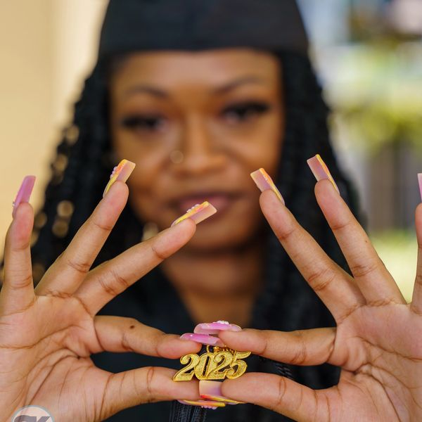 Person showing off 2025 ring with manicured nails.