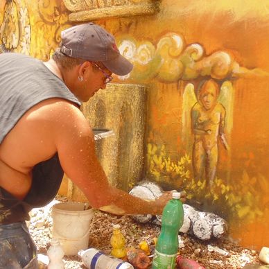Man painting a vibrant mural outdoors.