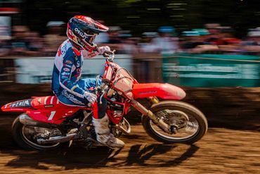 Motocross rider speeding on a dirt track during a race.
