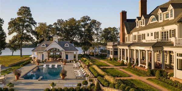 Luxury estate with pool and landscaped grounds overlooking a waterfront.