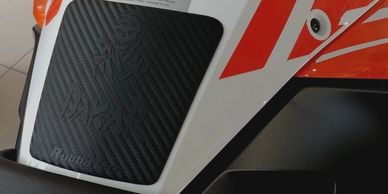 Rubber tank pad for various dual sports adventure motorcycles. Textured pad with carbon design, embo