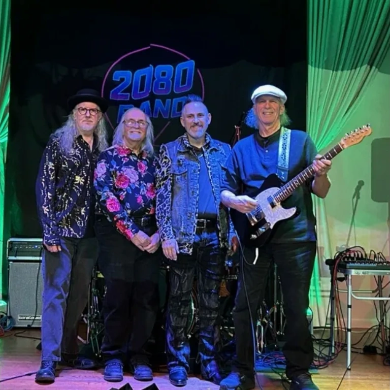Four men posing on stage in front of a "2080 BAND" sign.